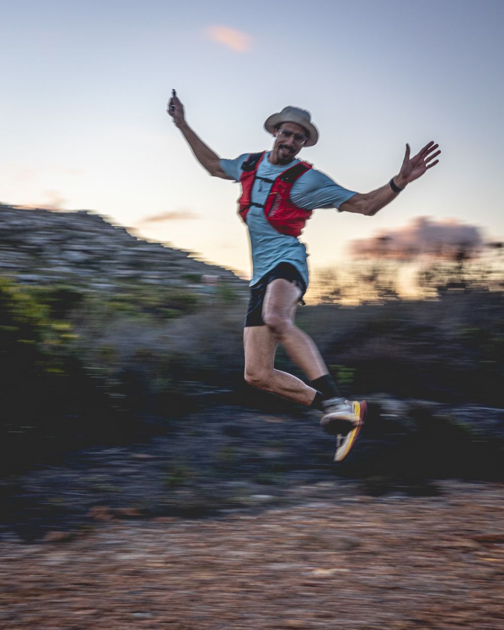 Dynamic action shot of runner mid-leap with arms spread wide showing joy